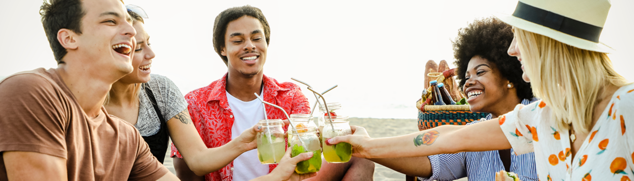 group-of-friends-drinking-fruit-infused-water-on-the-beach-having-a-picnic＂title=