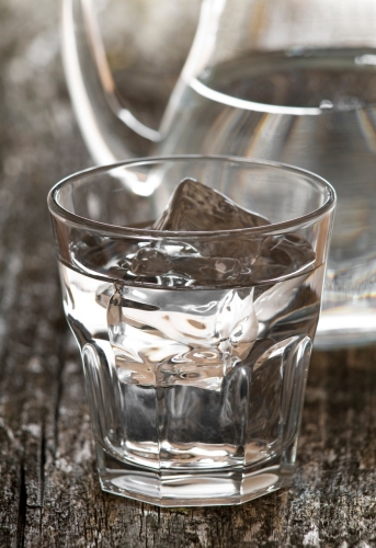 一杯卡布奇诺，漂亮的拿铁艺术和一杯水的特写。＂class=